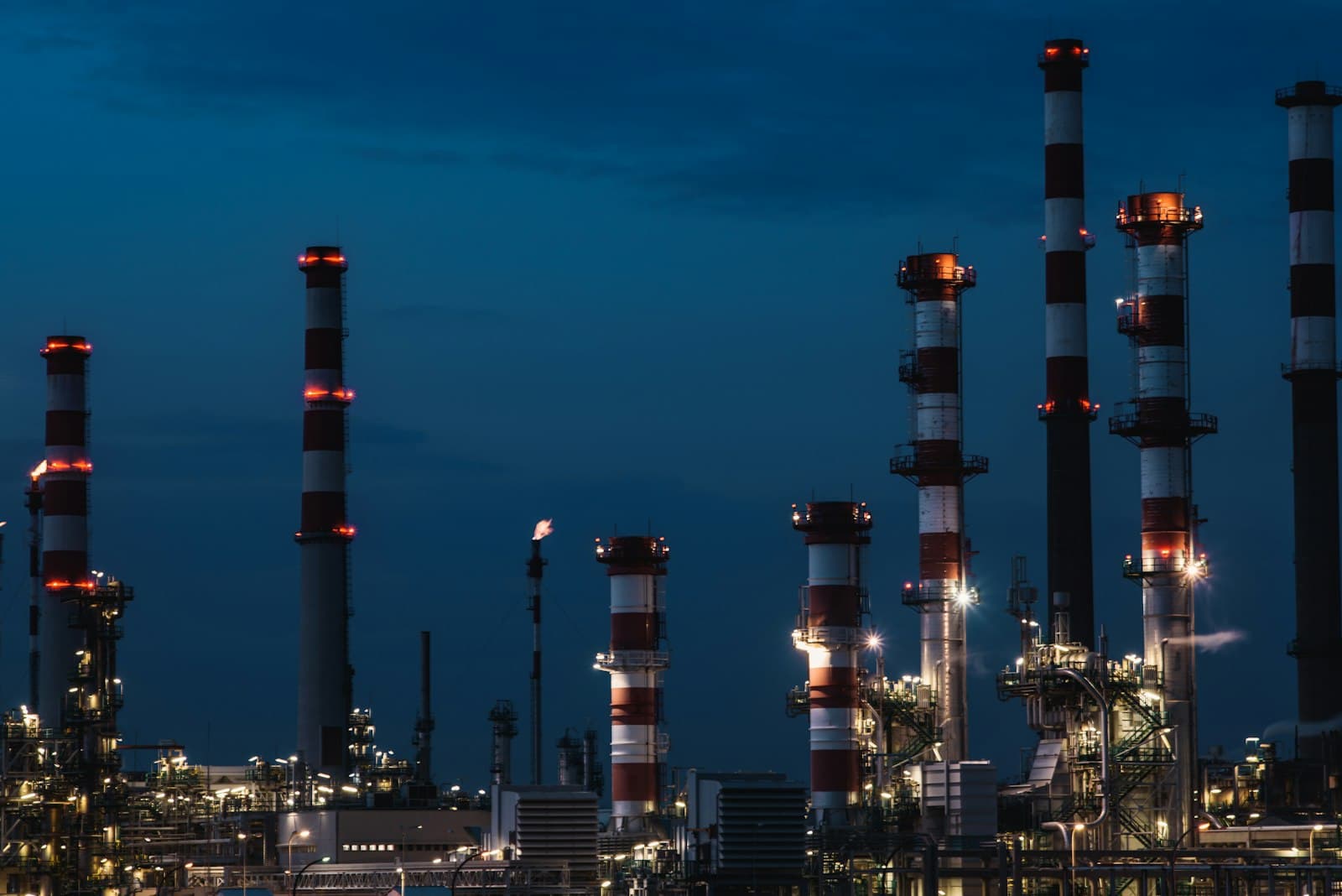 An industrial tower at an energy plant lit up at night
