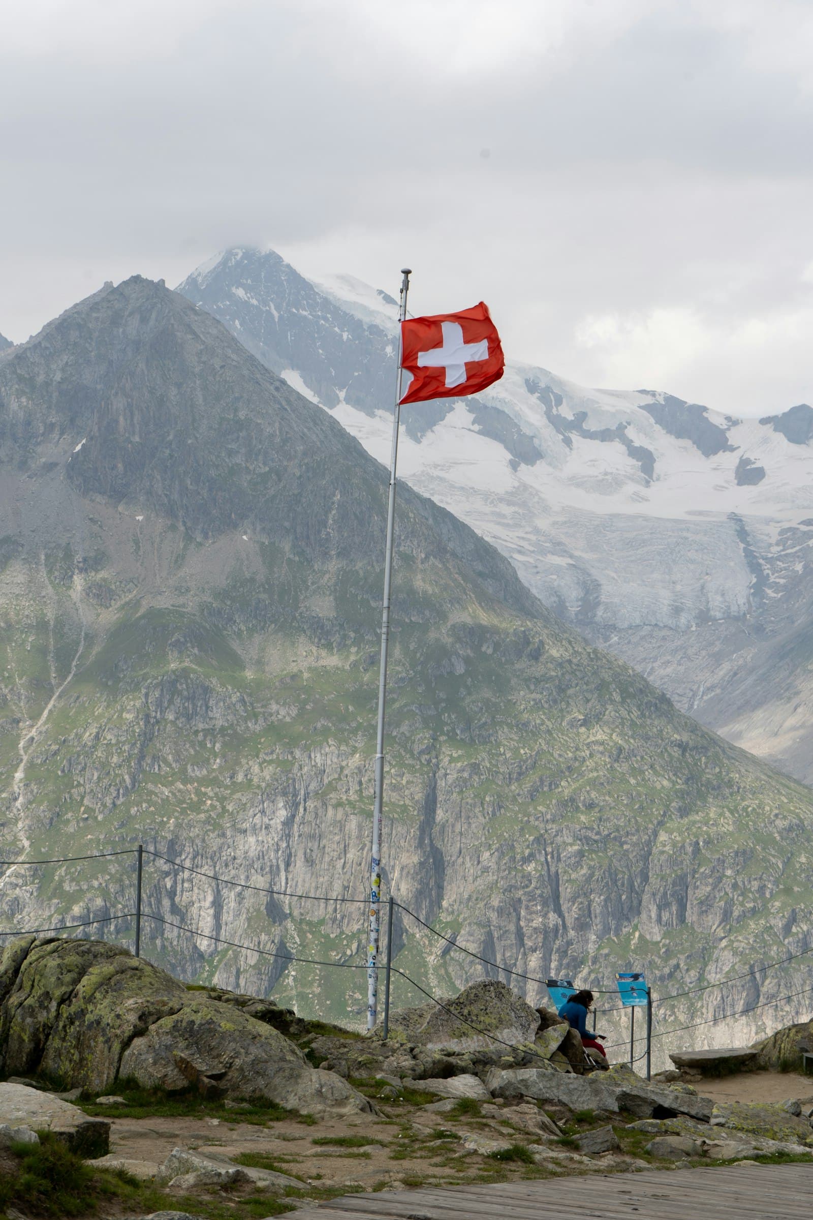 A Swiss flag waving on a mountainside