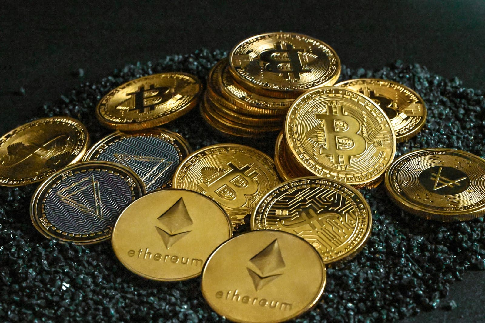 A pile of gold coins sitting on loose gravel